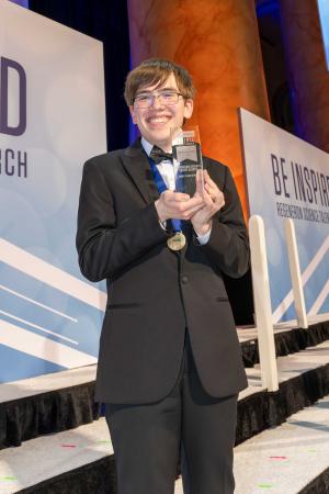 Connor HIll holding a trophy at the Regeneron STS award ceremony