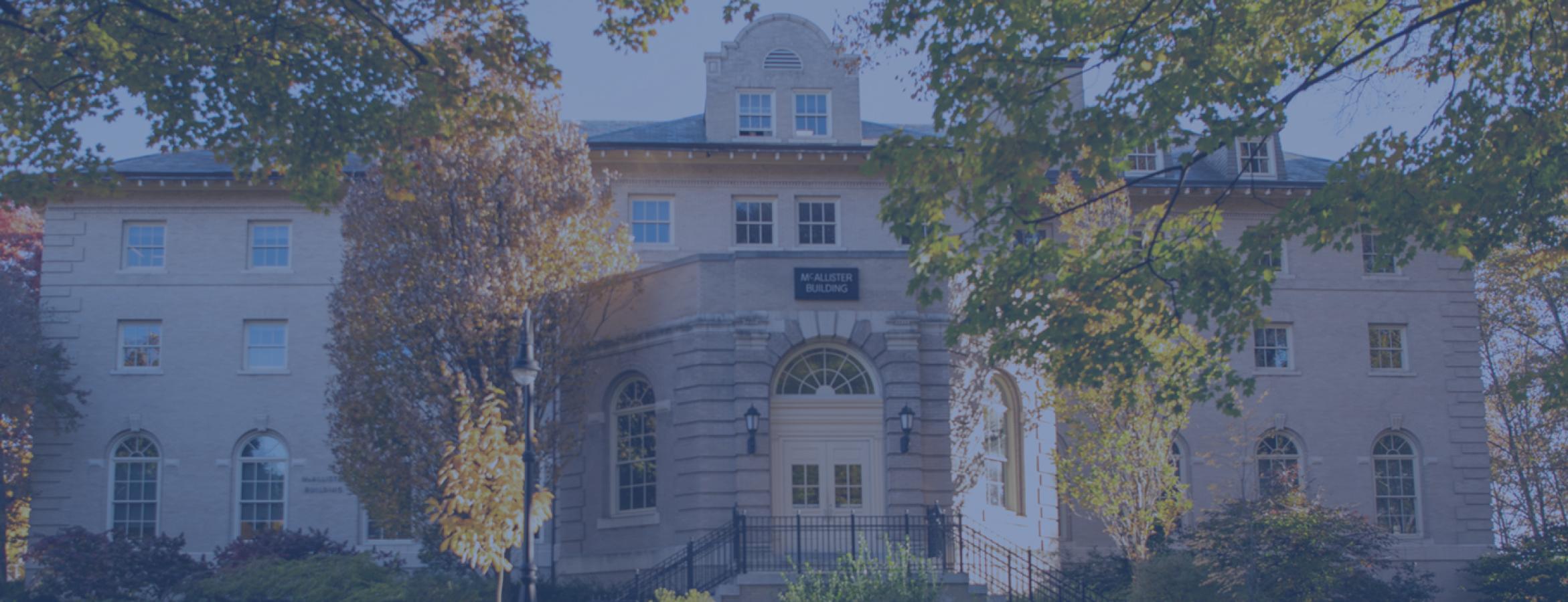 McAllister Building during the autumn with leaves on the ground in the foreground of the photo.