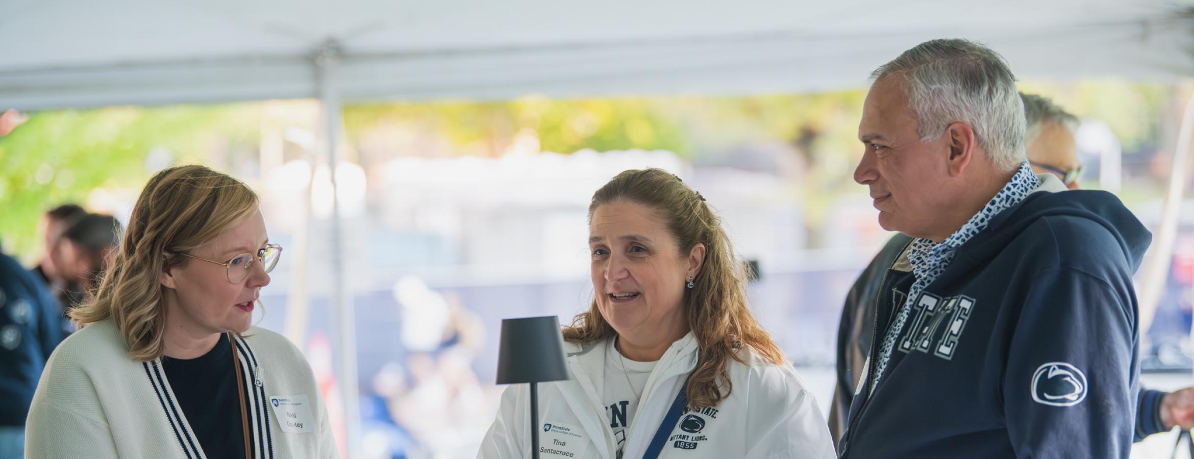 Nikki Crowley speaking to two attendees of the Penn State Homecoming tailgate.