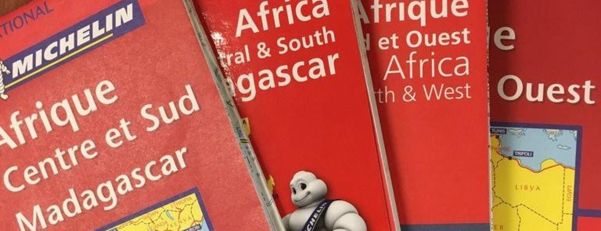 stack of four paper road maps of Africa