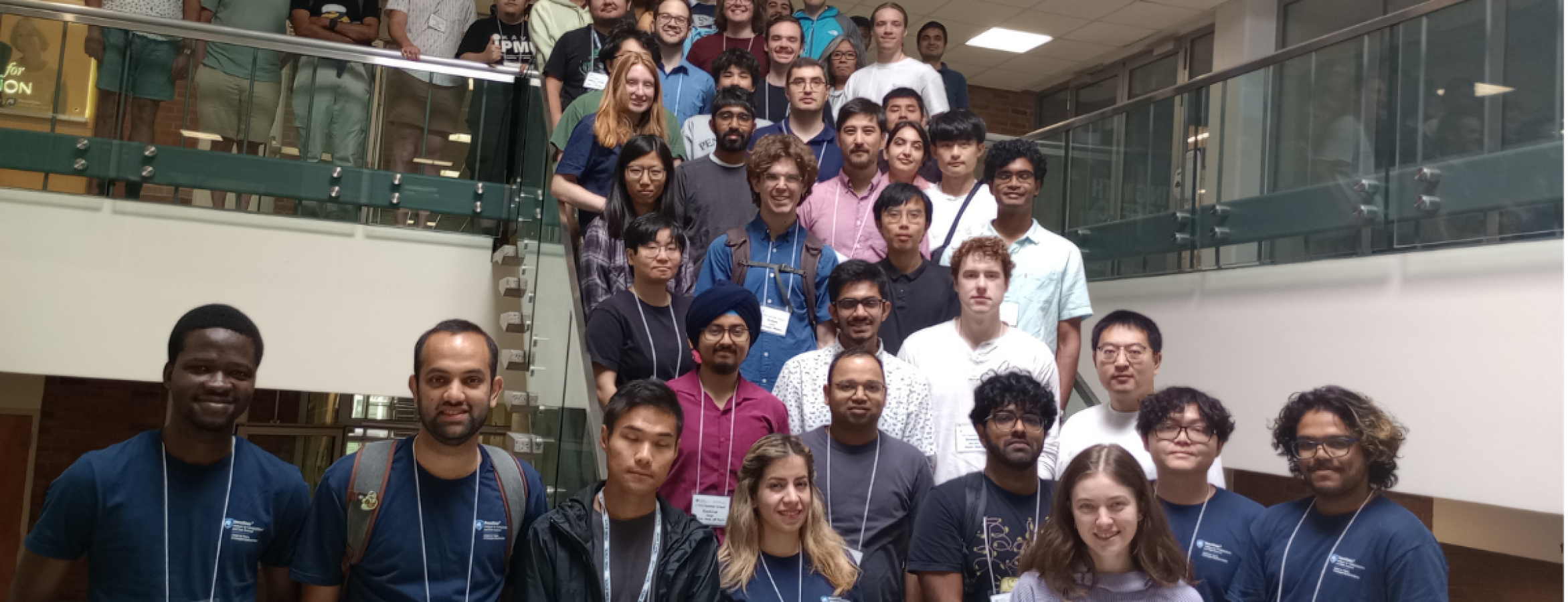 participants wearing name badges gather on staircase for posed photo
