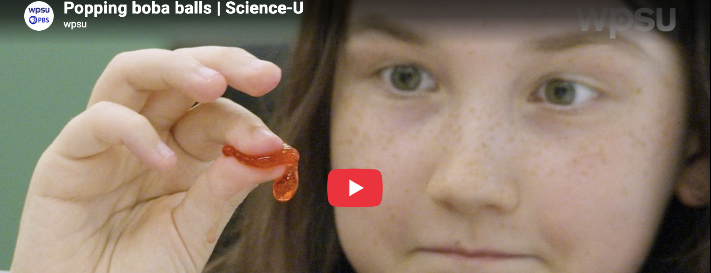 Girl participating in the Spherification Science-U at home experiment. This image is a close up of a girl popping one of the boba balls. 