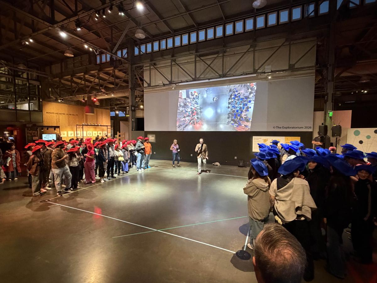 Picture of Karol Bacik at an outreach event, talking about crowd modeling. 