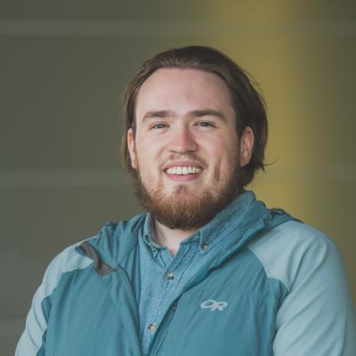 Photo of Drake Hale in a technical zip up and denim shirt