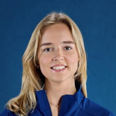 portrait of Ieva Evaltaite smiling in front of a blue background