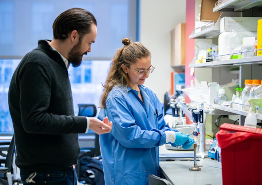 Jordan Bisanz and a member of his research group working in the laboratory.