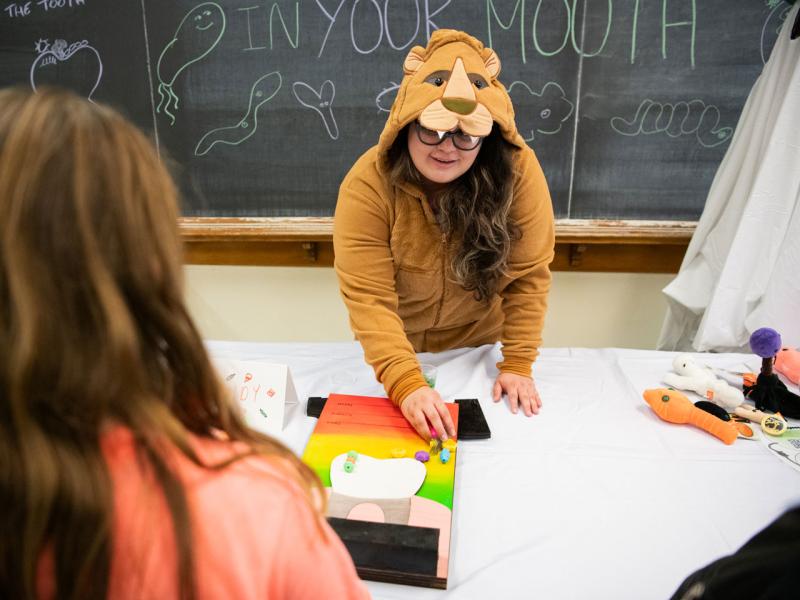  A staff lion working with an elementary-aged student during the 2024 Haunted University event