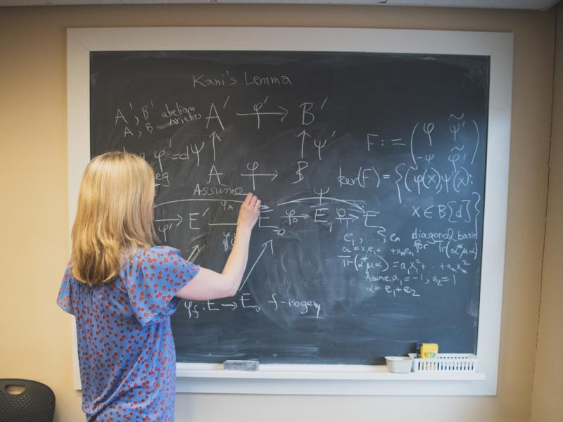 Kirsten Eisentraeger working on an equation on the chalkboard in her office.