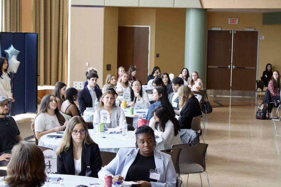 students at health professions conference sit at tables