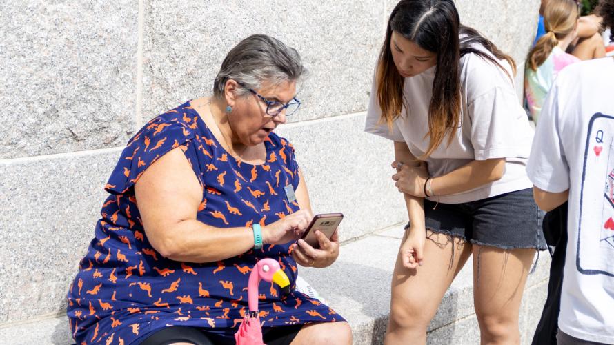 Carolyn Jensen, director of the college advising center, show a student resources on her mobile phone during the 2022 welcome day event.