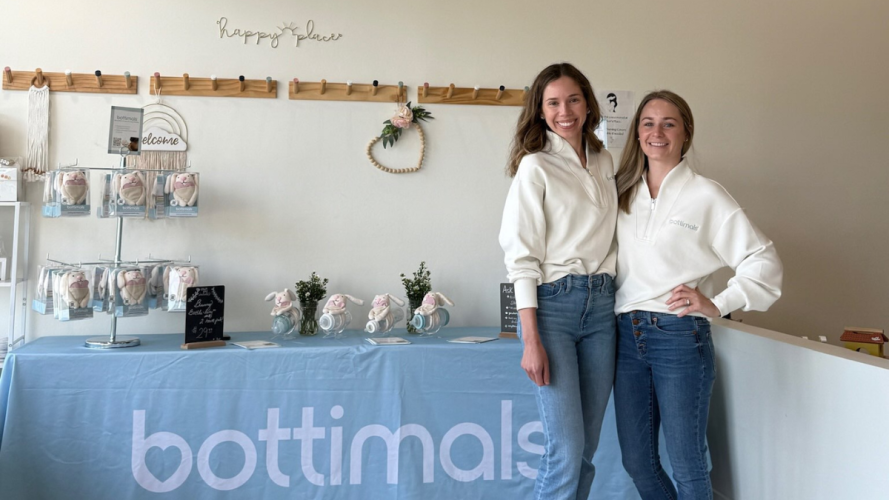 Julianne Gardner and Jill Cinalli standing in front of a table that says bottimals.