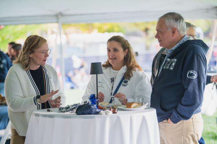 Nikki Crowley speaking to two attendees of the Penn State Homecoming tailgate.
