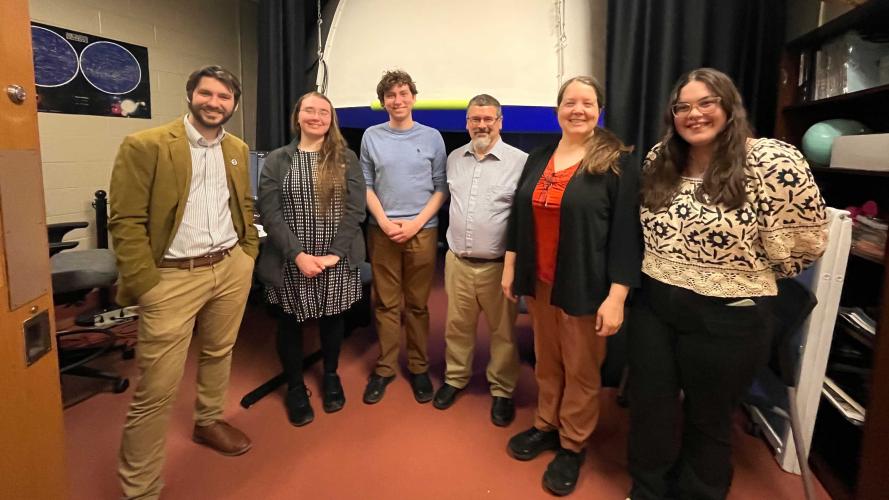 group of researchers in planetarium