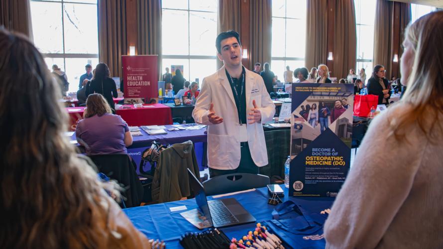A medical school representative speaks to two coeds during the 2026 Health Professions Expo.