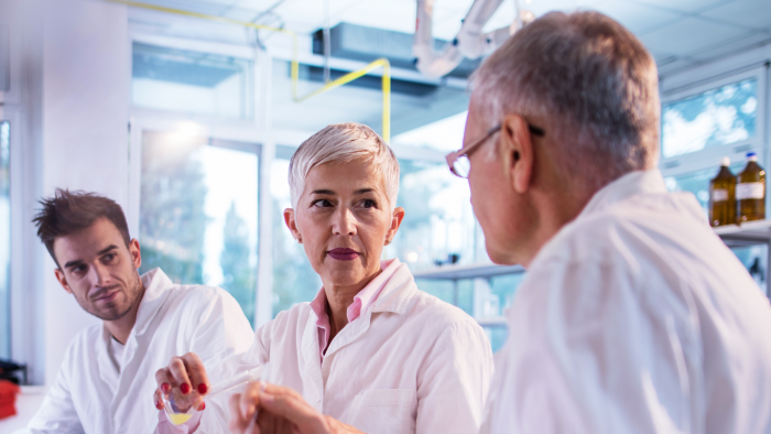 A researcher working with older industry representatives in the lab setting.