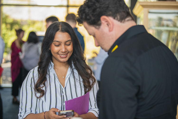 A student and a corporate representative interact at the fall 2025 career fair.
