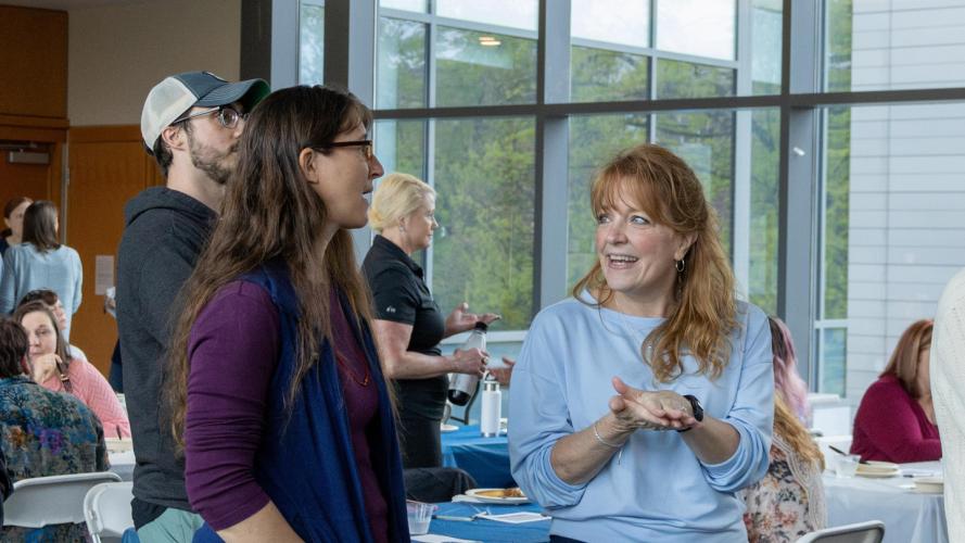 Two staff members for the statistics department talk as the wait in line during the staff appreciation breakfast.