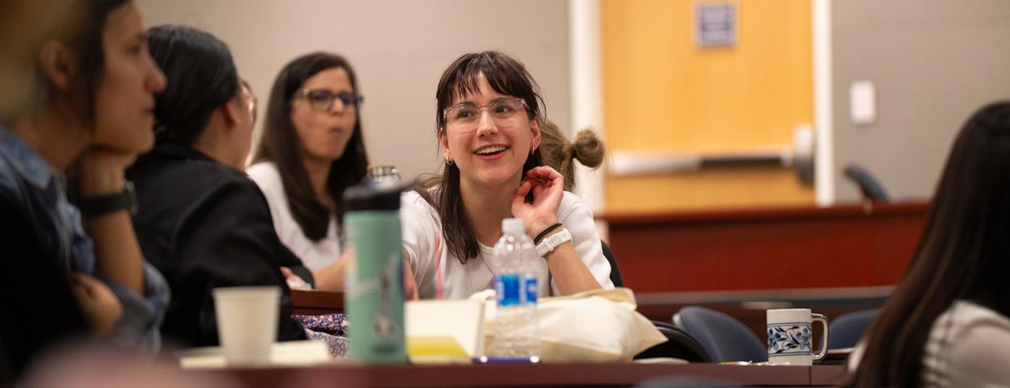 Participants in a small auditorium listening to a presentation during the 2024 One Health Microbiome Symposium.