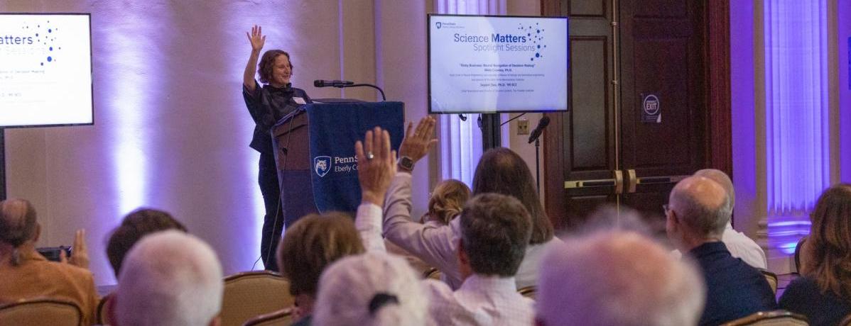 Tracy Langkilde, dean of the Eberly College of Science, raising her hand with audience members also raising their hands.