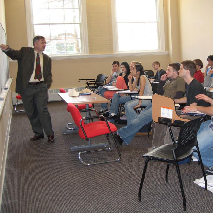 A professor pointing to the chalkboard during a class lecture.