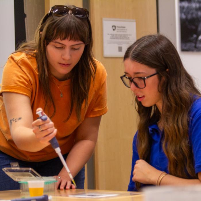 A research in Sarah Bordenstein's lab working with a high school student during an outreach event.