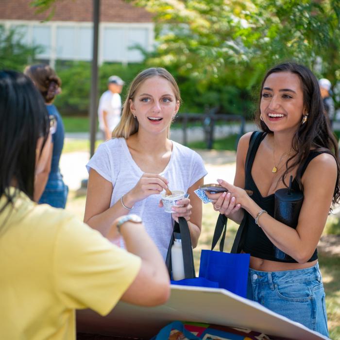 Two coeds talking with a college staff member during the fall 2025 college involvement fair.