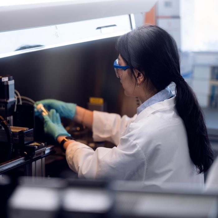 A research working under a hood at the science complex at the University Park campus.