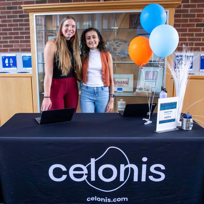 Kristina Kaldon and friend stand at table with Celonis tablecloth