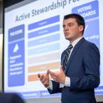 Student Adam Lieb wears suit and presents for business ethics team