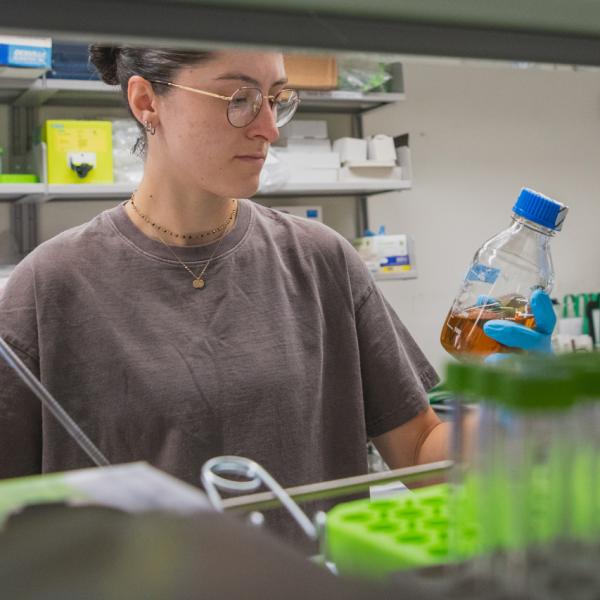 Graduate student Julia Mudryk holds a vial in the lab