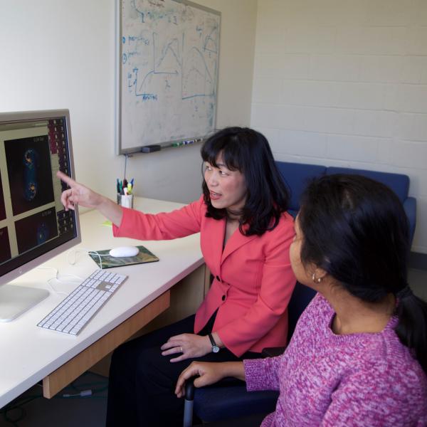 An astronomy professor and her student working at a computer.