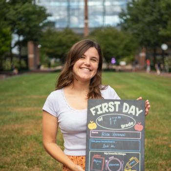 Alice Heranwal holding a first day of school board.