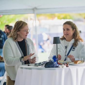 Nikki Crowley speaking to two other attendees of the Penn State Homecoming tailgate. 