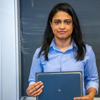Individual holding an award.