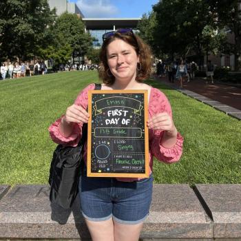 Student holding a first day of school chalkboard.
