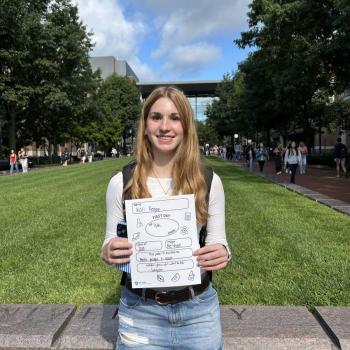 Student holding a first day of school paper sign.