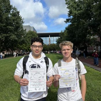 Two students holding first day of school paper signs.