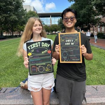Two students holding first day of school chalkboards.