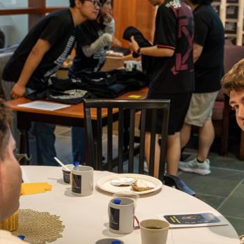 Students talking as the sit at a table during the Statistics Department Lightning Talks.