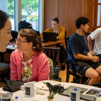 A professor in the statistics department talking with other participants during the event
