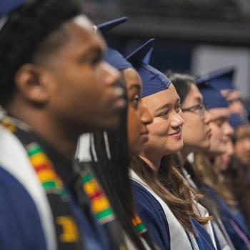 A row of sitting students listening to the speakers during the ceremony