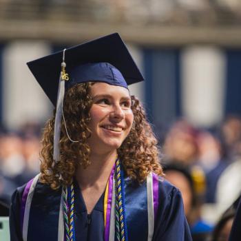 A coed student smiles as she leaves the stage.