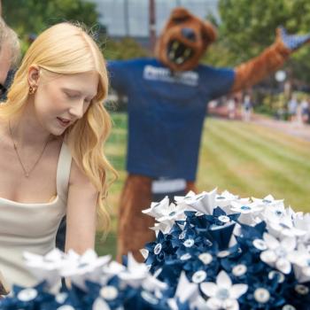A coed and guest admiring the paper bouquets at the reception.