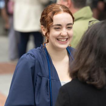 A future graduating talking to a member of the faculty during the reception.