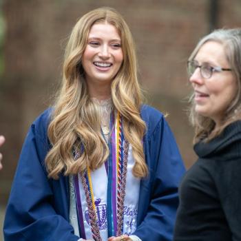 A coed and her mother talking and smiling during the commencement reception