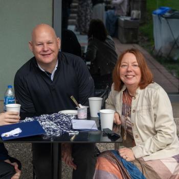 A future graduate sits with his family while enjoying refreshments from the brunch.