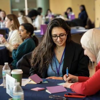  Small group of attendees talking at a round table during the event.