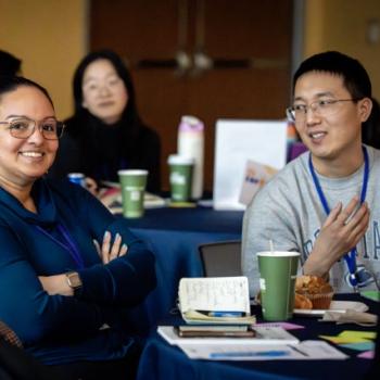  Small group of attendees talking at a round table during the event.