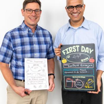 Ken Knappenberger and Santhosh Girirajan holding first day of school signs.