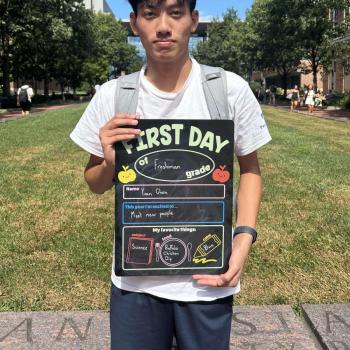 Science student holding a first day of school board.